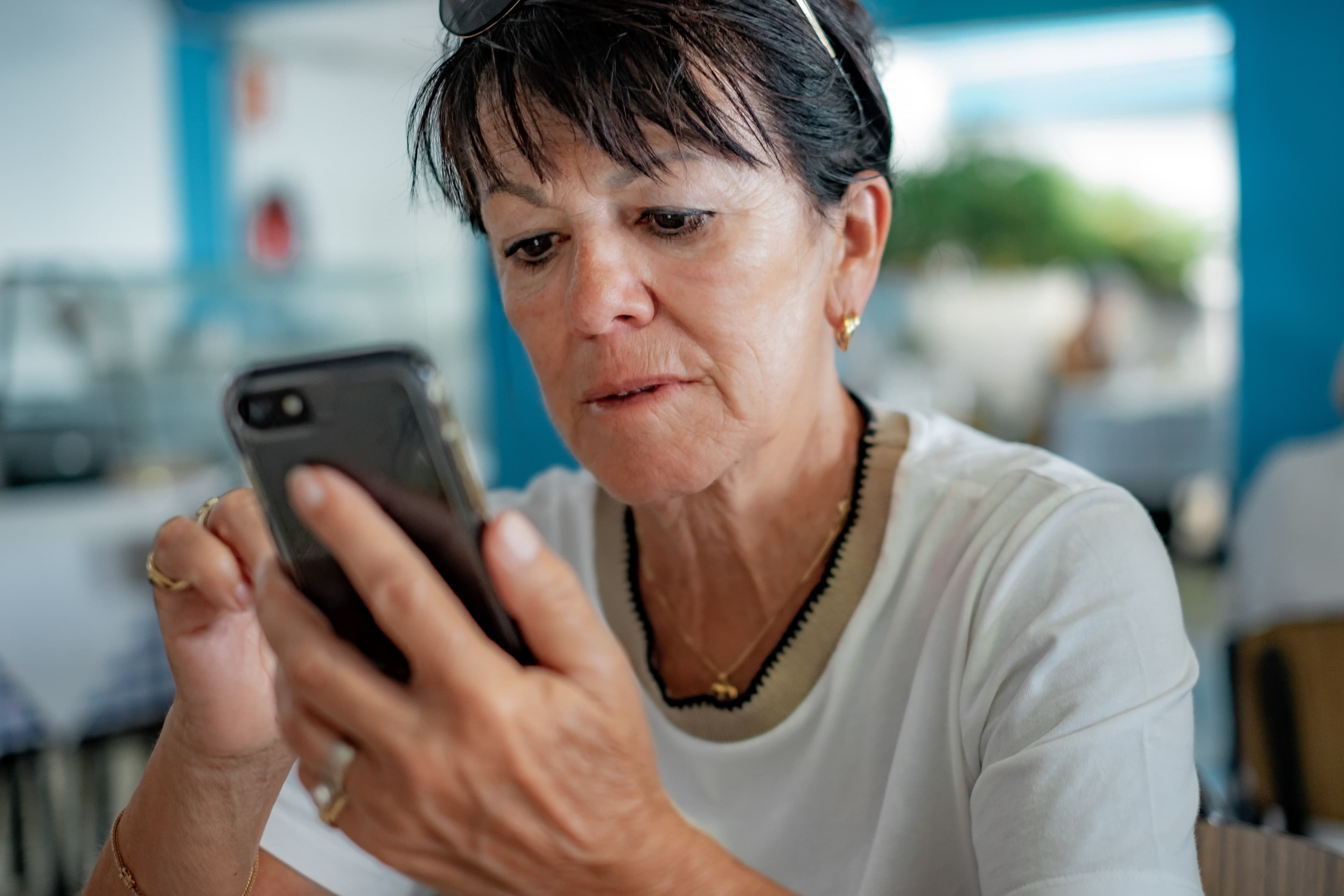 Eine Angehörige schaut besorgt auf ihr Handy